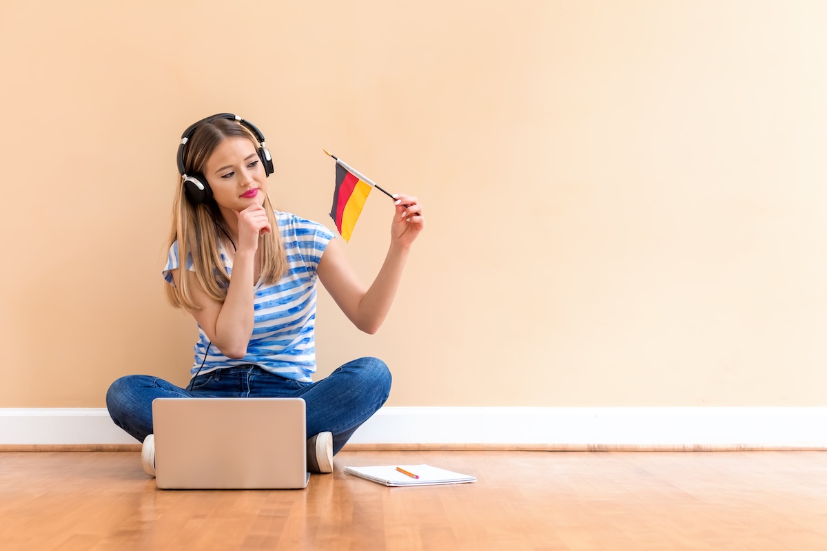 Junge Frau mit Deutschland-Flagge und Laptop – Lernen Sie Deutsch flexibel im Online-Deutschkurs, wo immer Sie sind!